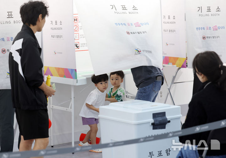  [부산=뉴시스] 하경민 기자 = 제9회 전국동시지방선거일인 3일 부산 부산진구청 백양홀에 마련된 부암1동 제4투표소를 찾은 어린이들이 부모와 함께 투표하고 있다. 2026.06.03. yulnetphoto@newsis.com