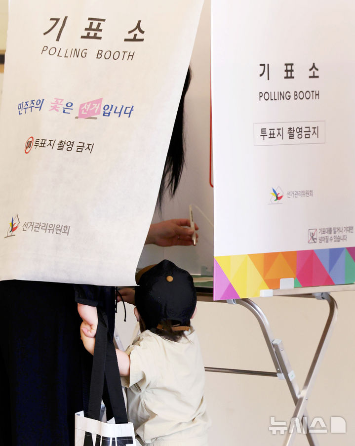 [서울=뉴시스 홍효식 기자 = 제9회 전국동시지방선거일인 3일 서울 광진구 기아자동차 대공원대리점에 마련된 능동 제3투표소에서 한 어린이가 엄마의 투표 행사를 지켜보고 있다. 2026.06.03. yesphoto@newsis.com
