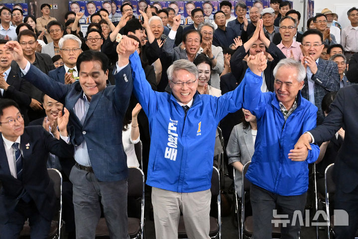[광주=뉴시스] 이영주 기자 = 민형배(가운데) 더불어민주당 전남광주통합특별시장 후보가 3일 오후 광주 서구 자신의 선거사무소에서 방송3사 출구조사 결과에 환호하고 있다. 2026.06.03. leeyj2578@newsis.com