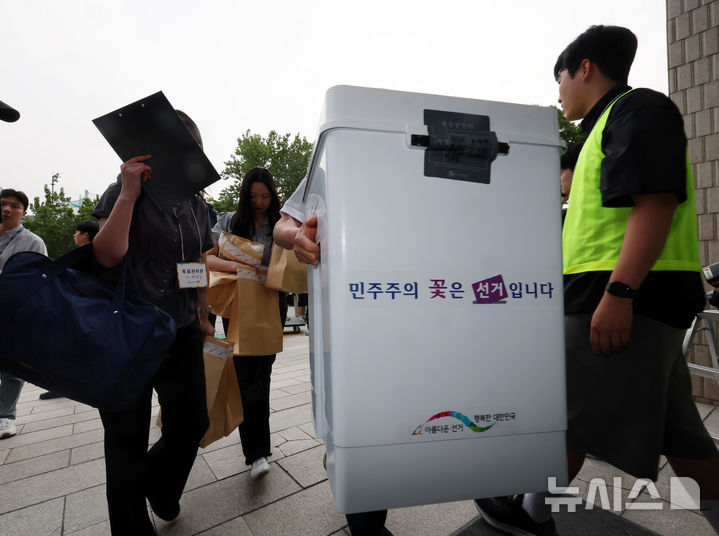 [서울=뉴시스] 배훈식 기자 = 제9회 전국동시지방선거일인 3일 오후 서울 관악구 서울대학교 종합체육관에 마련된 개표소에 투표 사무원과 참관인들이 투표함을 나르고 있다. 2026.06.03. dahora83@newsis.com