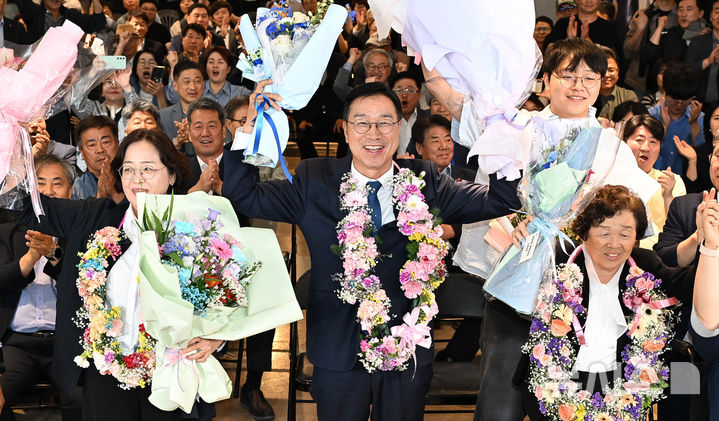 [제주=뉴시스] 우장호 기자 = 위성곤 더불어민주당 제주도지사 후보가 3일 오후 제주시 오라2동에 위치한 선거사무소에서 당선이 확실시 되자 부인 오수은씨와 함께 꽃다발을 목에 걸고 환호하고 있다. (사진=제주도사진기자회) 2026.06.03. woo1223@newsis.com