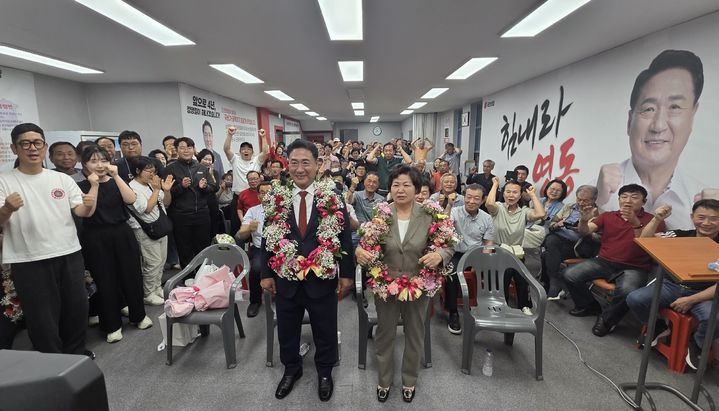 [영동=뉴시스] 국민의힘 정영철 충북 영동군수 후보가 3일 그의 선거사무소에서 부인과 함께 지지자들로부터 꽃다발과 박수 세례를 받고 있다. (사진=공동취재단) 2026.06.03. photo@newsis.com *재판매 및 DB 금지