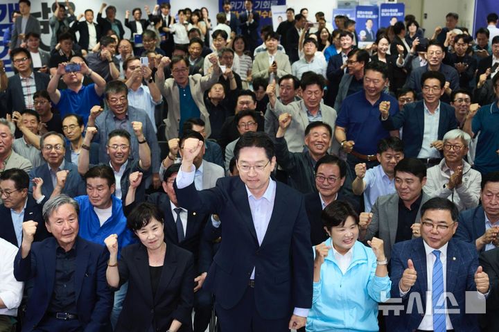 [창원=뉴시스]더불어민주당 김경수 경남도지사 후보가 4일 오후 6시 창원 선거사무소에서 방송3사 출구조사를 시청하던 중 당선 예측으로 나오자 일어나 지지자들에게 인사하고 있다.(사진=김경수 후보 캠프 제공)2026.06.03. photo@newsis.com