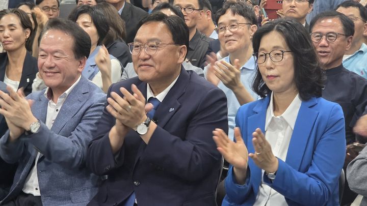 [세종=뉴시스] 송승화 기자 = 3일 나성동 선거 캠프에서 (가운데)조상호 더불어민주당 세종시장 후보와 배우자가 개표 방송을 보며 박수를 치고 있다. 2026.06.03. ssong1007@newsis.com. *재판매 및 DB 금지
