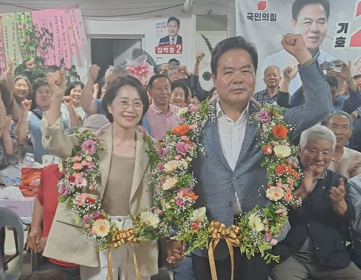 [문경=뉴시스] 4일 제9회 전국동시지방선거에서 당선한 김학홍 문경시장 당선인이 부인과 함께 꽃다발을 목에 걸고 당선의 기쁨을 나누고 있다. 2026.06.04. photo@newsis.com *재판매 및 DB 금지
