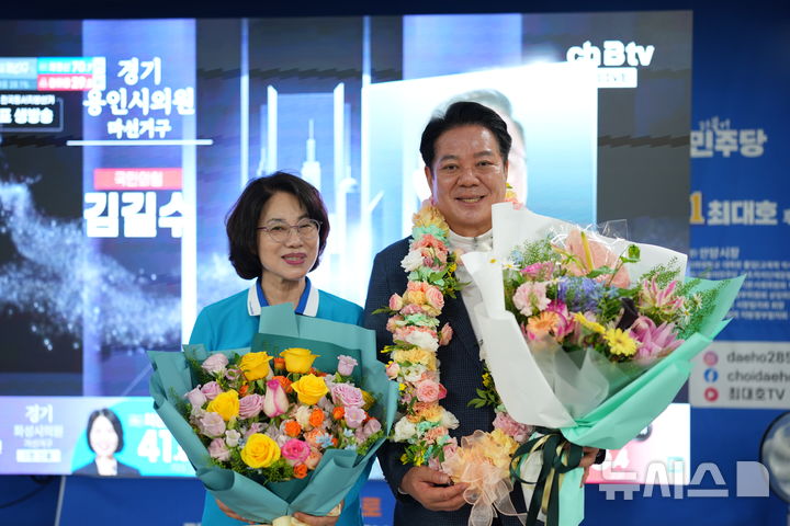 [안양=뉴시스] 최대호 안양시장 당선인이 지지자들이 건네 꽃다발을 않고 배우자와 함께 당선의 기쁨을 누리고 있다. (사진=선거사무소 제공).2026.06.04.photo@newsis.com