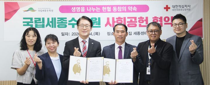 [대전=뉴시스] 4일 성낙준(왼쪽) 대전세종충남혈액원장과 강신구 국립세종수목원장이 헌혈 확산을 위한 협약을 체결한 뒤 양기관 관계자들과 기념촬영을 하고 있다. (사진=대한적십자사 대전세종충남혈액원 제공) 2026.06.04. photo@newsis.com *재판매 및 DB 금지