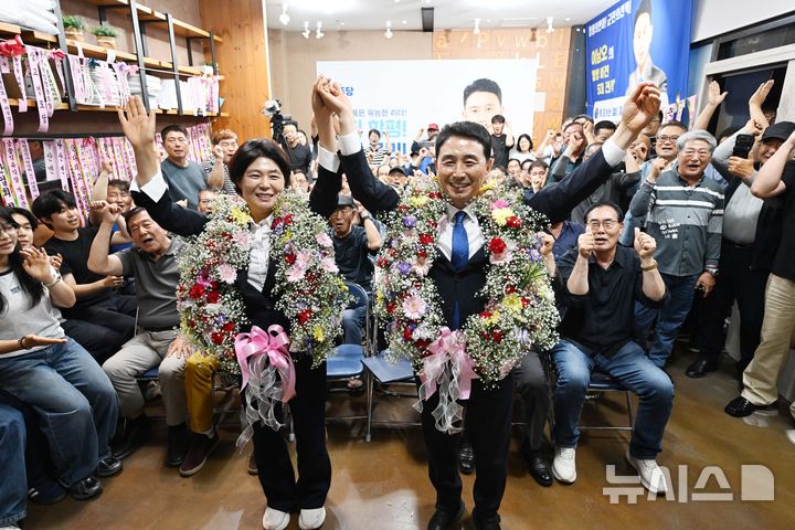 [함평=뉴시스] 이현행 기자 = 제9회 전국동시지방선거 전남 함평군수로 당선된 더불어민주당 이남오(오른쪽) 당선인이 4일 오전 함평군 함평읍 자신의 선거사무소에서 아내 이수인씨와 꽃목걸이를 걸고 만세 하고 있다. 2026.06.04. lhh@newsis.com