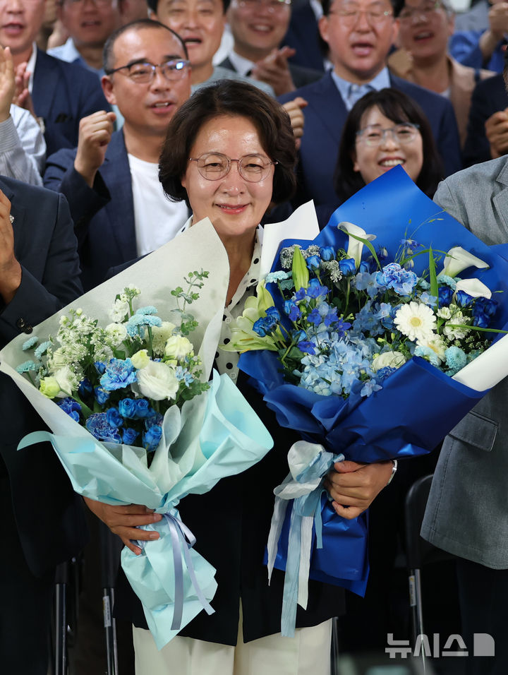 [수원=뉴시스] 김종택 기자 = 추미애 더불어민주당 경기도지사 후보가 4일 오전 경기 수원시 팔달구 마라톤빌딩에 마련된 선거사무소에서 당선이 확실시 되자 축하 꽃다발을 받고 있다. (공동취재) 2026.06.04. photo@newsis.com