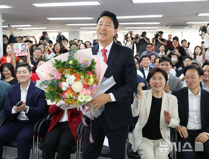 [서울=뉴시스] 황준선 기자 = 서울시장 당선이 확실시된 오세훈 국민의힘 후보가 4일 오전 서울 종로구 선거사무실에서 꽃다발을 들고 기념촬영 하고 있다. 2026.06.04. hwang@newsis.com