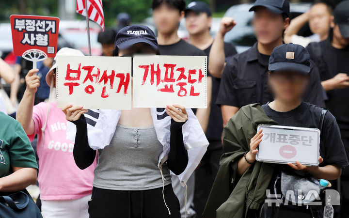 [서울=뉴시스] 홍효식 기자 = 4일 6·3 지방선거 투표용지 부족 사태를 겪은 서울 송파구 잠실7동 제2투표소 앞에서 시민들이 '선거관리위원회 해체, 부정선거, 재선거' 구호를 외치고 있다. 2026.06.04. yesphoto@newsis.com