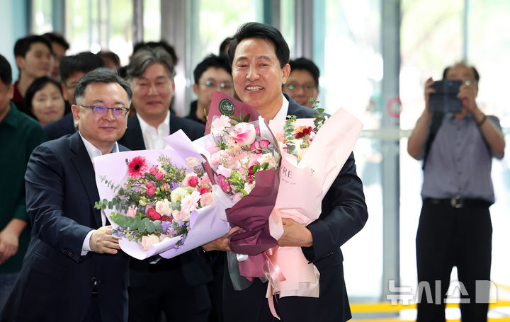 [서울=뉴시스] 김선웅 기자 = 오세훈 서울특별시장 당선인이 4일 서울시청으로 들어서며 직원들에게 꽃다발을 받고 있다. 2026.06.04. mangusta@newsis.com