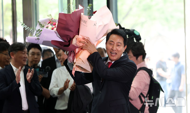 [서울=뉴시스] 김선웅 기자 = 오세훈 서울특별시장 당선인이 4일 서울시청으로 들어서며 직원들에게 받은 꽃다발을 들고 기뻐하고 있다. 2026.06.04. mangusta@newsis.com