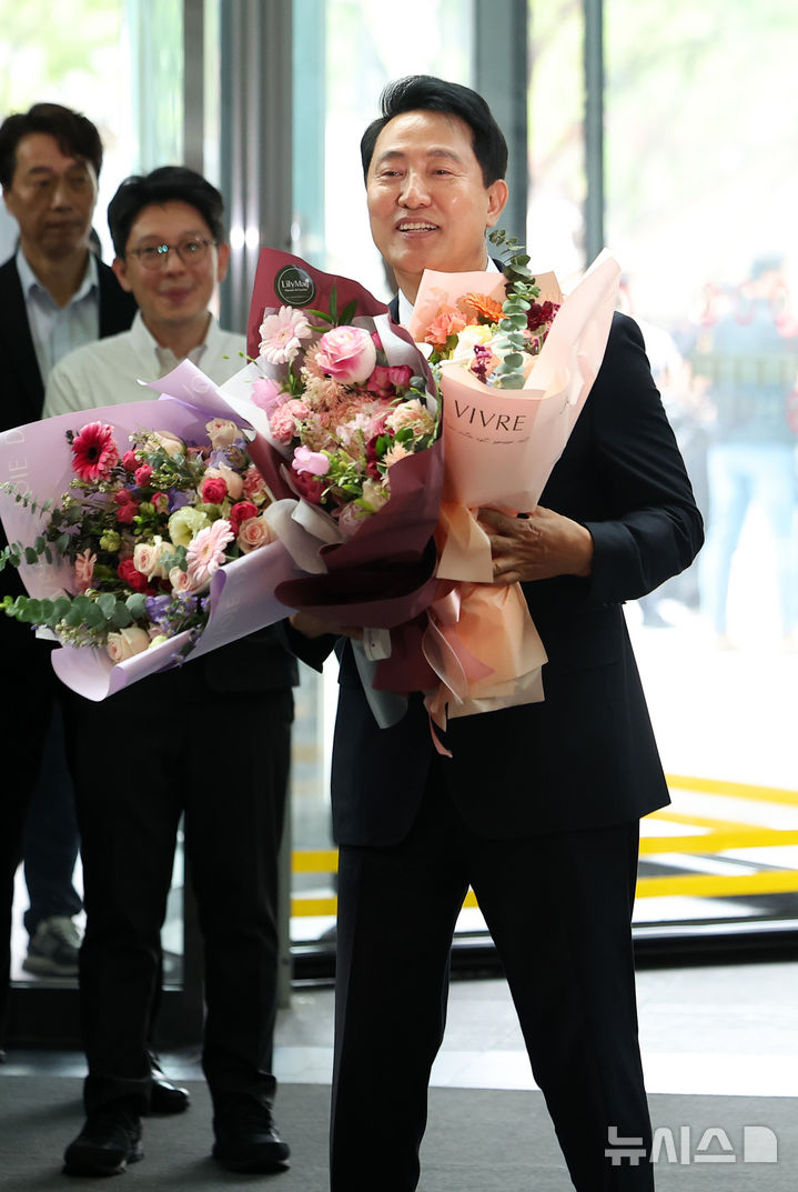 [서울=뉴시스] 김선웅 기자 = 오세훈 서울특별시장 당선인이 4일 서울시청으로 들어서며 직원들에게 꽃다발을 받고 있다. 2026.06.04. mangusta@newsis.com