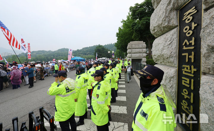 [과천=뉴시스] 조성우 기자 = 4일 경기 과천시 중앙선거관리위원회 과천청사 앞에서 투표용지 부족 사태 관련 항의 집회가 이어지는 가운데 경찰이 청사 내에서 경계 근무를 서고 있다. 2026.06.04. xconfind@newsis.com