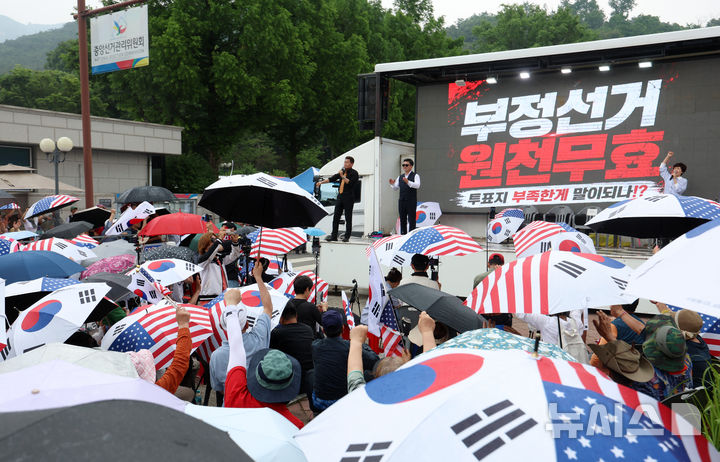 [과천=뉴시스] 조성우 기자 = 4일 경기 과천시 중앙선거관리위원회 과천청사 앞에서 열린 투표용지 부족 사태 관련 항의 집회에서 참가자들이 구호를 외치고 있다. 2026.06.04. xconfind@newsis.com