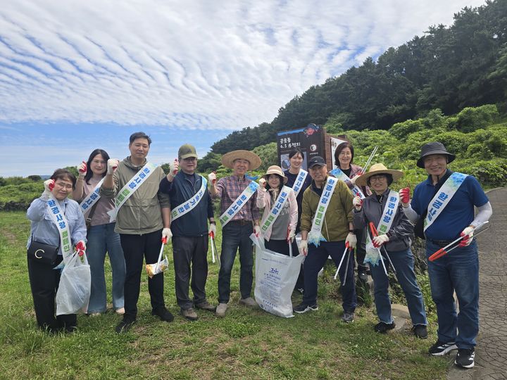 [제주=뉴시스] 제주중장년내일센터 관계자들이 5일 제주시 화북동 곤을동 일대에서 환경사랑 캠페인을 전개하고 기념사진을 촬영하고 있다. (사진=제주중장년내일센터 제공) 2026.06.05. photo@newsis.com *재판매 및 DB 금지