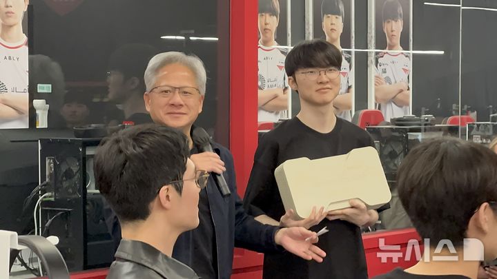 [서울=뉴시스] 윤정민 기자 = 젠슨 황 엔비디아 최고경영자(CEO, 왼쪽)과 리그 오브 레전드(LoL) 프로게이머 '페이커' 이상혁이 5일 오후 서울 마포구 T1 베이스캠프에서 사인한 RTX 5090을 선물로 증정하는 행사를 진행했다. 2026.06.05. alpaca@newsis.com