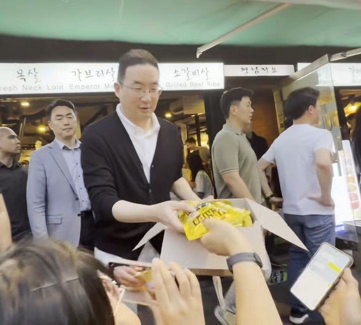 [서울=뉴시스] 구광모 LG그룹 회장이 5일 서울 마포구 한 식당 앞에서 SK하이닉스가 만든 반도체 콘셉츠 과자 '허니바나나맛 HBM 칩스'를 관중들에게 나눠주고 있다. 2026.06.05 photo@newsis.com *재판매 및 DB 금지