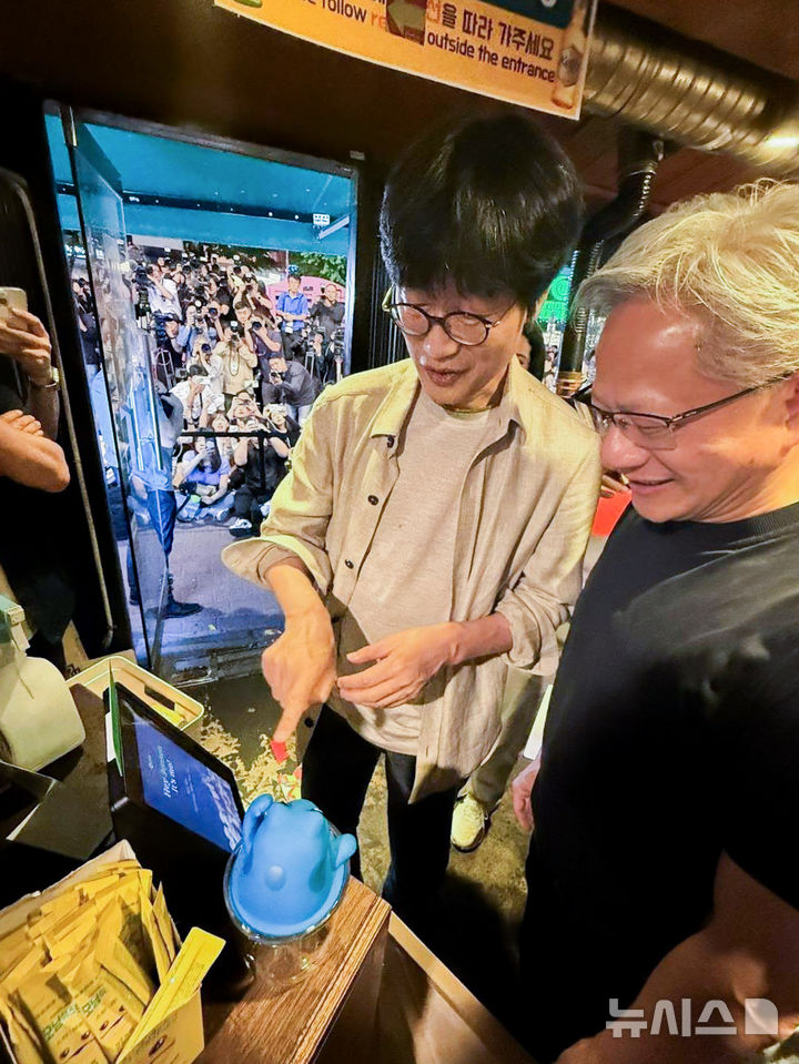 [서울=뉴시스] 이해진 네이버 의장(왼쪽)이 5일 오후 서울 마포구에 위치한 한 식당에서 젠슨 황 엔비디아 최고경영자(CEO)에게 네이버 오프라인 결제 단말기 'Npay 커넥트'를 소개하고 있다. 이 의장은 이날 황 CEO가 주최한 '삼쏘(삼겹살+소주) 회동'뿐만 아니라 식당 내 모든 테이블을 결제했다. (사진=네이버 제공)