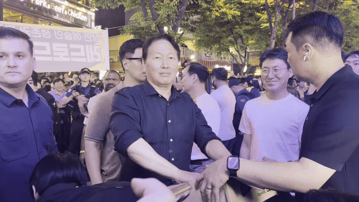 [서울=뉴시스] 최태원 SK그룹 회장이 5일 서울 마포구 홍대 BBQ에서 열린 젠슨 황 엔비디아 최고경영자(CEO)과의 2차 회동 중 잠시 밖으로 나와 시민들에게 HBM칩스 과자를 나눠주고 있다. 2026.06.05 photo@newsis.com