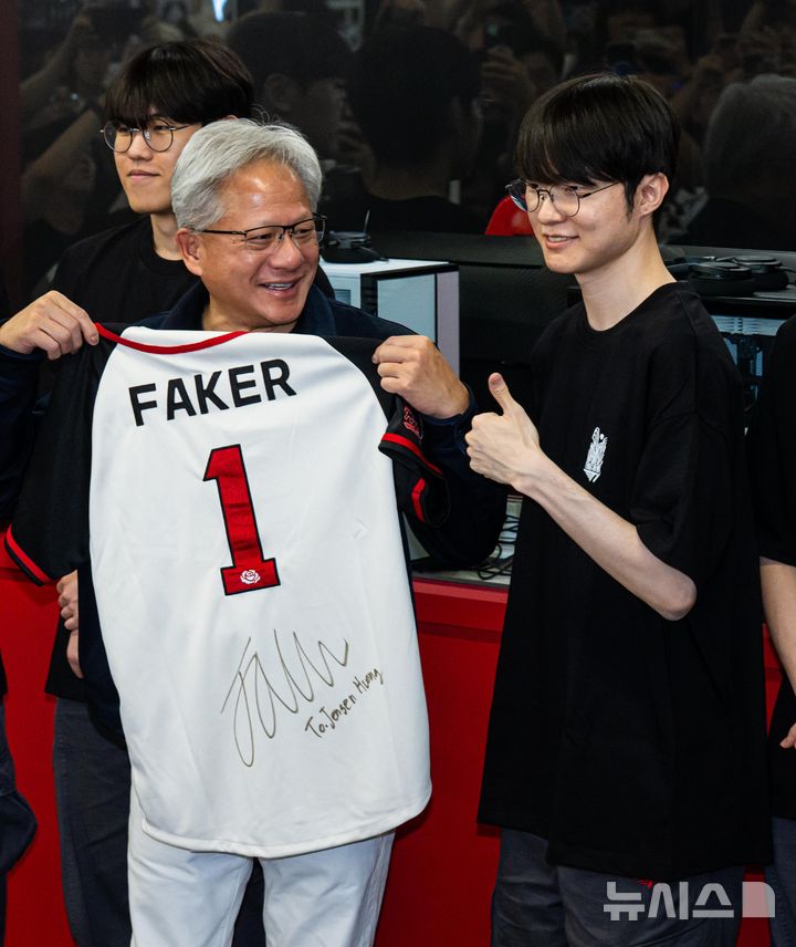 [서울=뉴시스] 조성우 기자 = 젠슨 황 엔비디아 최고경영자(CEO)가 5일 서울 마포구 ‘T1 베이스 캠프’를 방문해 ‘페이커‘ 이상혁을 비롯한 e스포츠 구단 T1의 리그 오브 레전드(LoL) 선수단을 만나서 ‘페이커’의 사인이 담긴 기념품을 선물 받고 있다. (공동취재) 2026.06.05. photo@newsis.com
