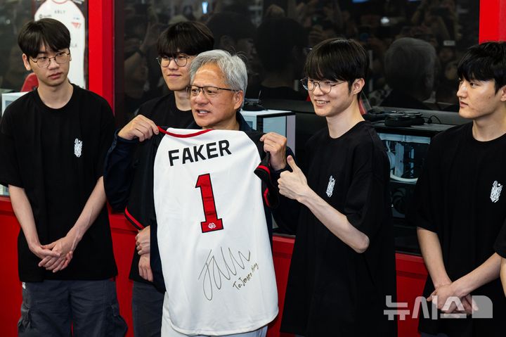 [서울=뉴시스] 조성우 기자 = 젠슨 황 엔비디아 최고경영자(CEO)가 5일 서울 마포구 ‘T1 베이스 캠프’를 방문해 ‘페이커‘ 이상혁을 비롯한 e스포츠 구단 T1의 리그 오브 레전드(LoL) 선수단을 만나서 ‘페이커’의 사인이 담긴 기념품을 선물 받고 있다. (공동취재) 2026.06.05. photo@newsis.com