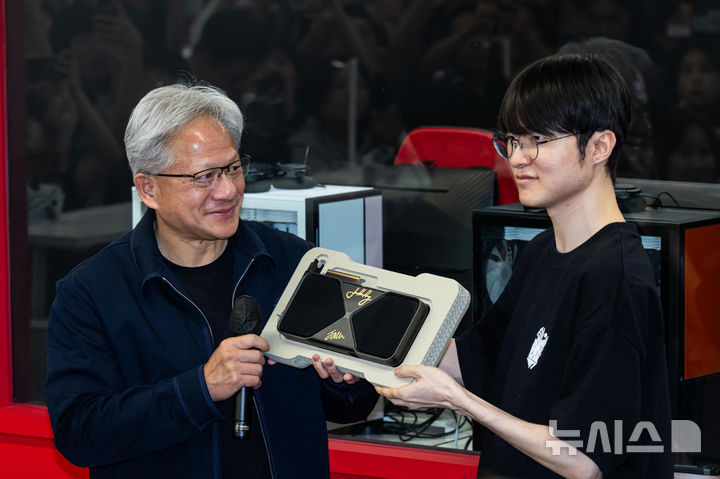 [서울=뉴시스] 조성우 기자 = 젠슨 황(왼쪽) 엔비디아 최고경영자(CEO)가 5일 서울 마포구 'T1 베이스 캠프'에서 '페이커' 이상혁을 만나서 엔비디아의 차세대 플래그십 그래픽카드인 ‘지포스 RTX 5090’을 선물하고 있다. (공동취재) 2026.06.05. photo@newsis.com