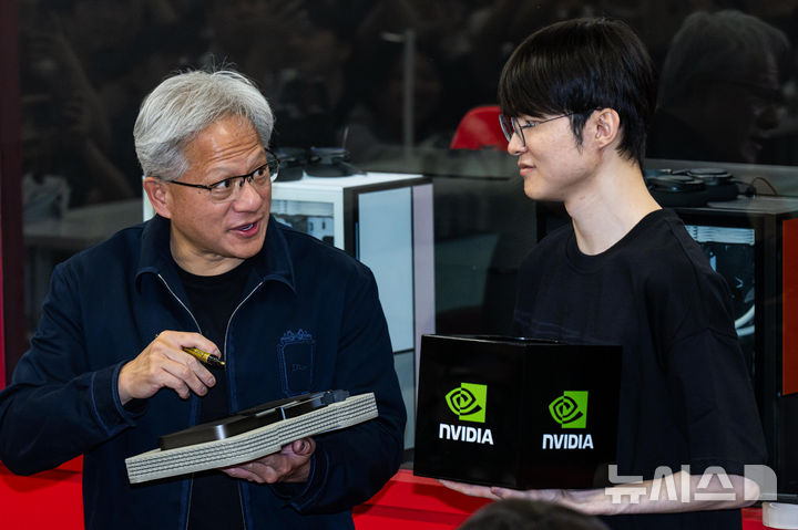 [서울=뉴시스] 조성우 기자 = 젠슨 황(왼쪽) 엔비디아 최고경영자(CEO)가 5일 서울 마포구 'T1 베이스 캠프'에서 '페이커' 이상혁을 만나서 엔비디아의 차세대 플래그십 그래픽카드인 ‘지포스 RTX 5090’을 선물하고 있다. (공동취재) 2026.06.05. photo@newsis.com