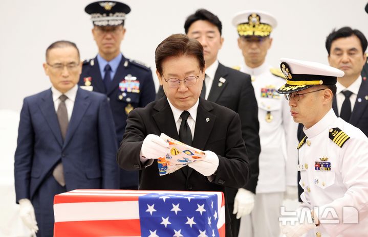 [성남=뉴시스] 고범준 기자 = 이재명 대통령이 5일 경기 성남시 서울공항에서 열린 한미 6·25전사자 유해 상호봉환식에서 미군 전사자 유해에 아리랑 스카프를 수여하고 있다. 2026.06.05. bjko@newsis.com