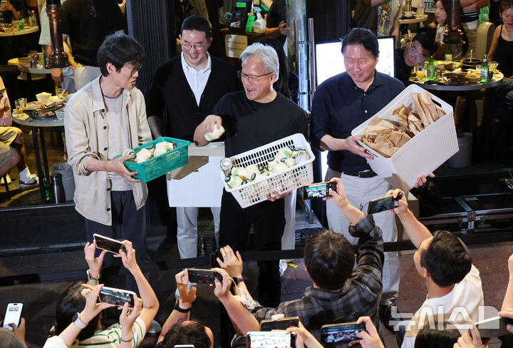 [서울=뉴시스] 조성우 기자 = 젠슨 황 엔비디아 최고경영자(CEO)가 5일 서울 마포구 홍대 인근의 한 고깃집에서 최태원 SK그룹 회장과 구광모 LG그룹 회장, 이해진 네이버 의장과 이른바 '삼소(삼겹살·소주) 회동' 도중 시민들에게 간식을 나눠주고 있다. 2026.06.05. xconfind@newsis.com