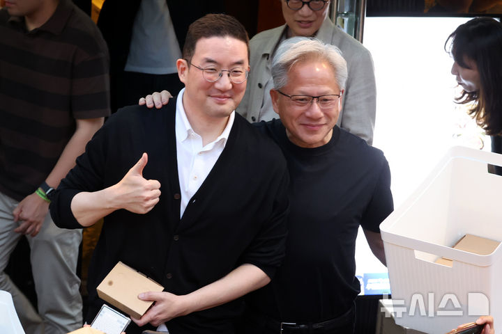 [서울=뉴시스] 조성우 기자 = 젠슨 황 엔비디아 최고경영자(CEO)가 5일 서울 마포구 홍대 인근의 한 고깃집에서 최태원 SK그룹 회장과 구광모 LG그룹 회장, 이해진 네이버 의장과 이른바 '삼소(삼겹살·소주) 회동' 도중 시민들에게 간식을 나눠주다 포즈를 취하고 있다. 2026.06.05. xconfind@newsis.com