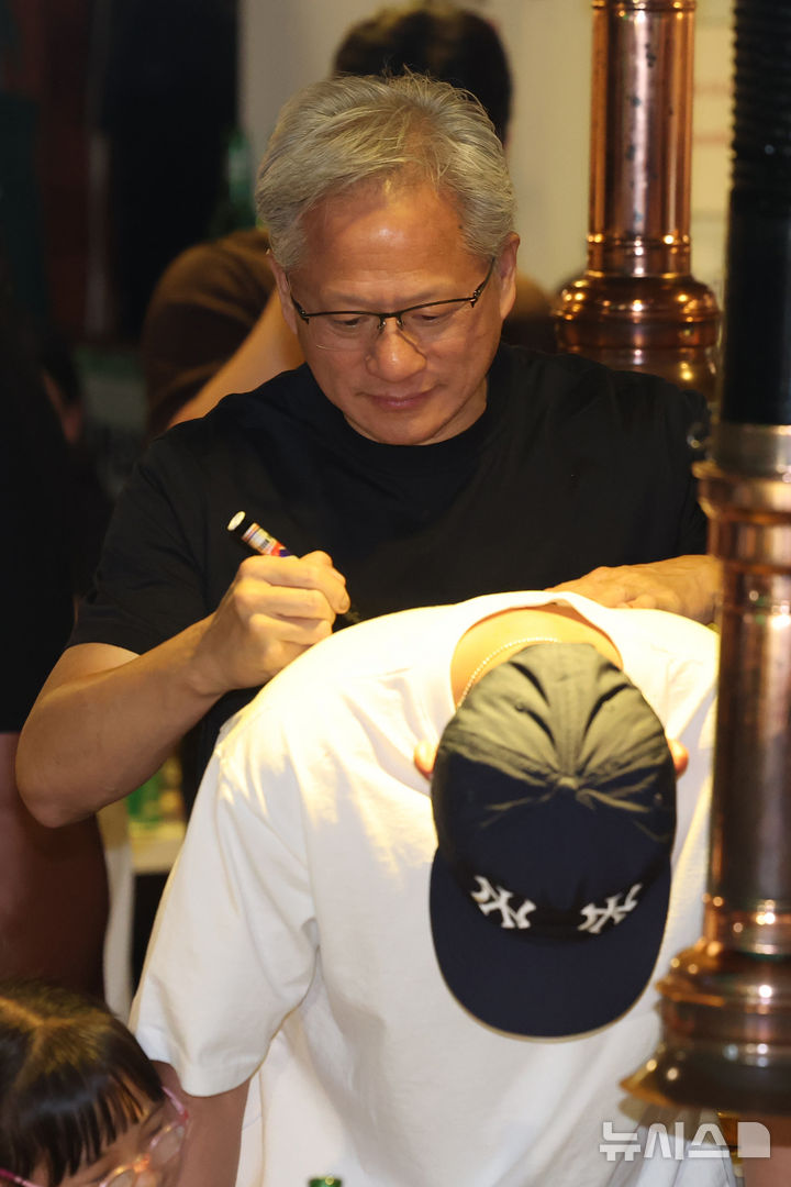 [서울=뉴시스] 조성우 기자 = 젠슨 황 엔비디아 최고경영자(CEO)가 5일 서울 마포구 홍대 인근의 한 고깃집에서 최태원 SK그룹 회장과 구광모 LG그룹 회장, 이해진 네이버 의장과 이른바 '삼소(삼겹살·소주) 회동' 도중 시민에게 사인을 해주고 있다. 2026.06.05. xconfind@newsis.com