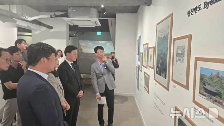 [전주=뉴시스] 국립공원공단 서부지역본부(본부장 김종식)와 전북특별자치도문화관광재단과 공동으로 전주 한옥마을 '하얀양옥집'에서 특별기획전 '국립공원, 예술로 피어나다 – 유람의 기록, 산을 걷다'를 개최한 가운데 관계자들이 설명을 듣고 있다. (사진= 국립공원공단 서부지역본부 제공) *재판매 및 DB 금지