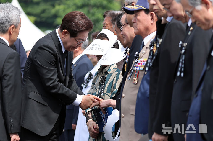 [서울=뉴시스] 고범준 기자 = 이재명 대통령이 6일 서울 동작구 국립서울현충원에서 열린 제71회 현충일 추념식에 입장하며 참석자들과 인사하고 있다. (청와대통신사진기자단) 2026.06.06. bjko@newsis.com