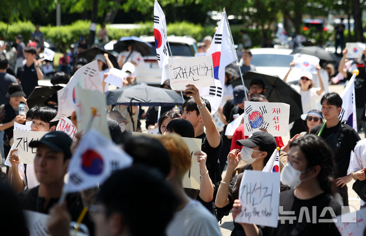 [서울=뉴시스] 김선웅 기자 = 제9회 전국동시지방선거 투표용지 부족 사태에 항의하며 개표소 봉쇄 시위를 이어가는 시민들이 6일 서울 송파구 올림픽공원 핸드볼경기장에 설치된 개표소 앞에서 재선거를 요구하고 있다. 2026.06.06. mangusta@newsis.com