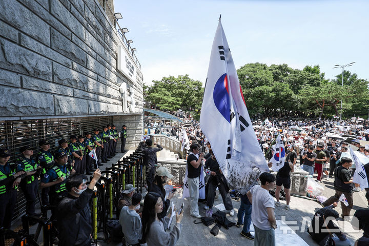 [서울=뉴시스] 김선웅 기자 = 제9회 전국동시지방선거 투표용지 부족 사태에 항의하며 개표소 봉쇄 시위를 이어가는 시민들이 6일 서울 송파구 올림픽공원 핸드볼경기장에 설치된 개표소 앞에서 재선거를 요구하고 있다. 2026.06.06. mangusta@newsis.com
