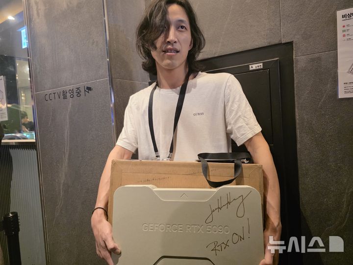 [서울=뉴시스]오동현 기자 = 젠슨 황 엔비디아 최고경영자(CEO)가 7일 서울 강남구의 한 PC방에서 열린 엔씨 '아이온2' 이용자 행사장에서 추첨을 통해 그래픽처리장치(GPU) 'RTX 5090'을 선물했다. 사진은 당첨자 민준홍(31)씨. odong85@newsis.com