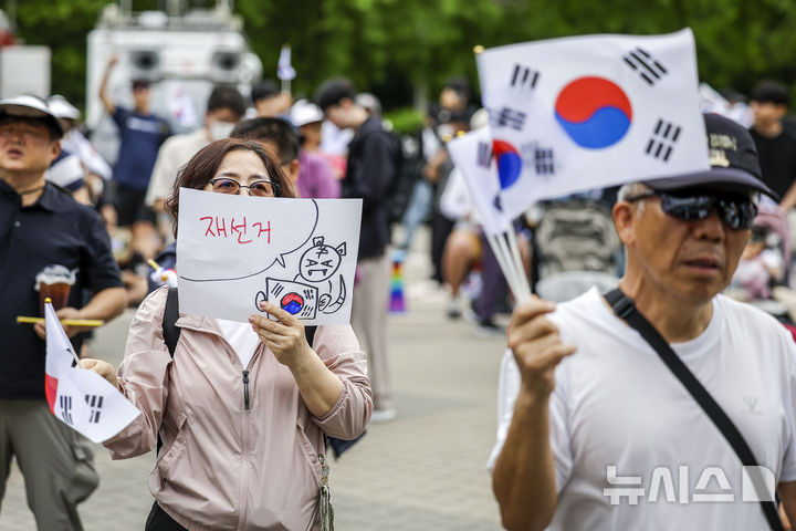 [서울=뉴시스] 정병혁 기자 = 제9회 전국동시지방선거 투표용지 부족 사태에 항의하며 개표소 봉쇄 시위를 이어가는 시민들이 7일 서울 송파구 올림픽공원 핸드볼경기장에 설치된 개표소 앞에서 재선거를 요구하고 있다. 2026.06.07. jhope@newsis.com