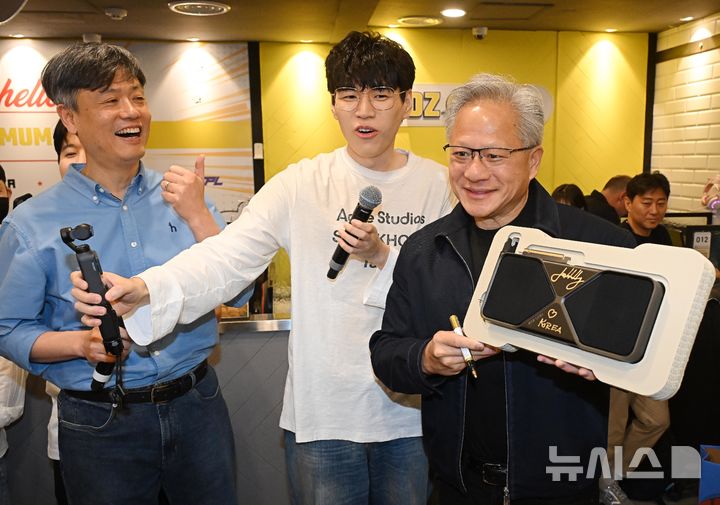 [서울=뉴시스] 정병혁 기자 = 젠슨 황 엔비디아 최고경영자(CEO)가 7일 서울 강남구의 한 PC방에서 크래프톤 유저에게 선물할 최신 그래픽카드 '지포스RTX5090'에 사인하고 있다. (공동취재) 2026.06.07. photo@newsis.com