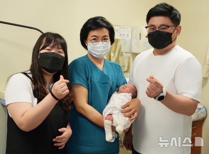 [서울=뉴시스] 고현선 서울성모병원 권역모자의료센터 산모태아부센터장(가운데)rhk 고위험 임신과정을 이겨내고 최근 건강하게 출산한 산모 가족. (사진= 서울성모병원 제공)