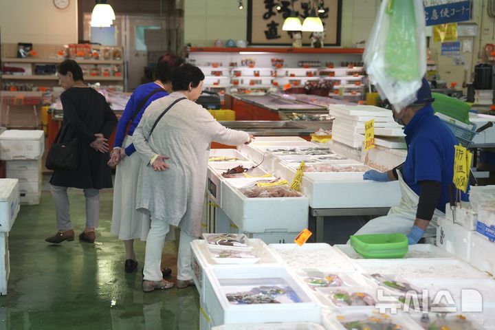 [이와키=AP/뉴시스] 일본 정부가 한국 정부에 일본산 수산물 수입 규제 해제를 논의하기 위한 실무 협의 개시를 타진한 것으로 전해졌다. 8일 일본 요미우리신문 등 현지 언론에 따르면 일본 정부는 일본산 수산물에 대한 수입 규제 철폐를 목표로 실무 수준에서 정기적으로 논의할 대화 창구를 마련해 달라고 한국 정부에 요청했다. 사진은 지난 2023년 10월19일 일본 후쿠시마현 이와키시 오나하마 어항 인근 수산시장에서 방문객들이 판매 중인 수산물을 살펴보고 있는 모습. 2026.06.08.
