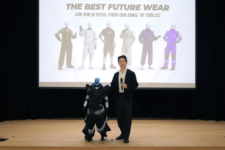[서울=뉴시스] 김익환 한세실업 부회장이 무대에 오른 휴머노이드 로봇과 함께 기념사진을 촬영하고 있다. (사진=한세실업 제공) 2026.06.08. photo@newsis.com *재판매 및 DB 금지