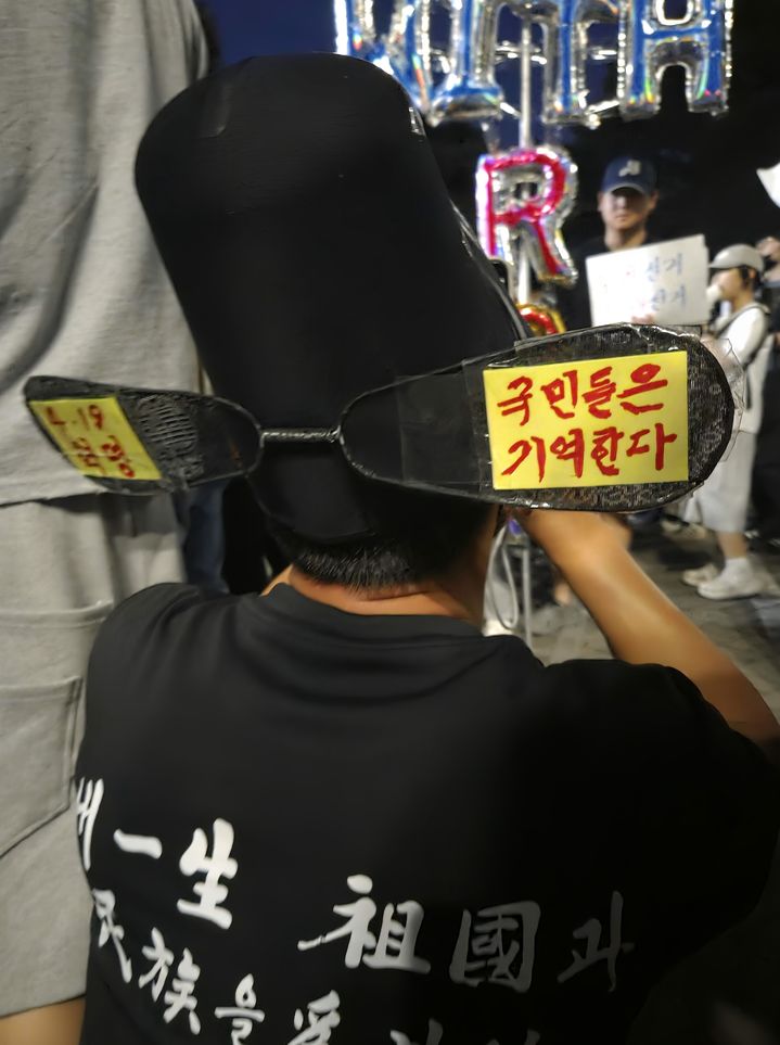 [서울=뉴시스] 이지영 기자= '4·19혁명, 국민들은 기억한다'는 문구가 적힌 모자를 쓴 60대 남성이 8일 오후 서울 송파구 잠실 개표소 봉쇄 시위에서 시위자들과 사진을 찍고 있다. 2026.06.08. jee0@newsis.com *재판매 및 DB 금지
