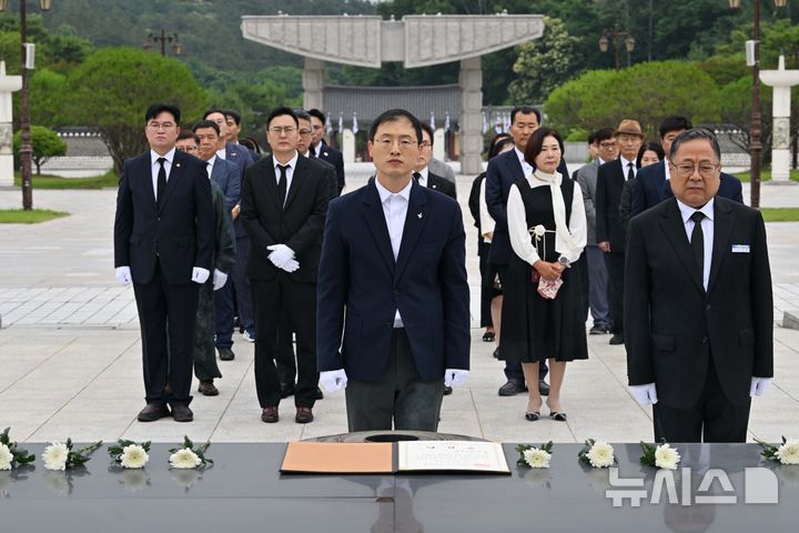 [광주=뉴시스] 이영주 기자 = 김상욱(가운데) 더불어민주당 울산시장 당선인이 8일 오전 광주 북구 운정동 국립5.18민주묘지를 찾아 오월 영령에 울산시장 당선증을 바친 뒤 참배하고 있다. 2026.06.08. leeyj2578@newsis.com