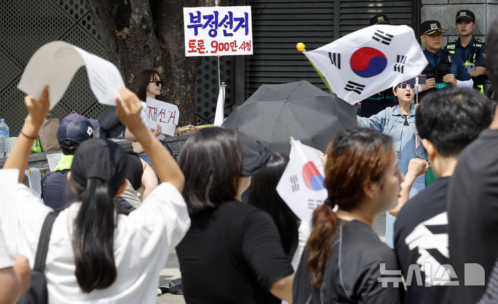 [서울=뉴시스] 김혜진 기자 = 제9회 전국동시지방선거 투표용지 부족 사태에 항의하며 개표소 봉쇄 시위를 이어가는 시민들이 8일 서울 송파구 올림픽공원 핸드볼경기장에 설치된 개표소 앞에서 재선거를 요구하고 있다. 2026.06.08. jini@newsis.com