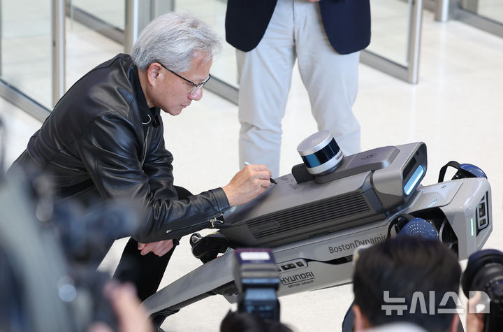 [서울=뉴시스] 김진아 기자 = 젠슨 황 엔비디아 최고경영자(CEO)가 8일 서울 서초구 현대차그룹 양재 사옥에서 4족 보행로봇 스팟(Spot)에 사인하고 있다. 2026.06.08. bluesoda@newsis.com
