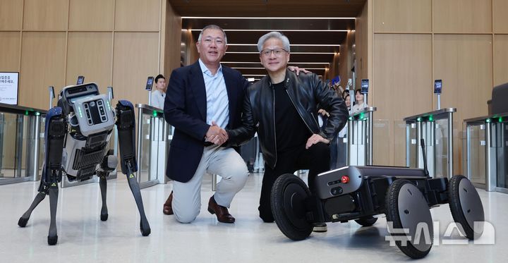 [서울=뉴시스] 김진아 기자 = 젠슨 황 엔비디아 최고경영자(CEO)와 정의선 현대차그룹 회장이 8일 서울 서초구 현대자동차그룹 양재사옥에서 4족 보행로봇 스팟(Spot)과 자율주행 모빌리티 로봇 모베드(MobED)에 사인한 뒤 기념촬영 하고 있다. (공동취재) 2026.06.08. photo@newsis.com