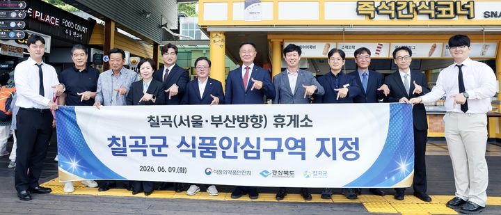 [칠곡=뉴시스] 김재욱(왼쪽 일곱번째) 군수가 칠곡휴게소(서울방향)에서 식품안심구역 지정 현판식 후 기념사진을 찍고 있다. (사진=칠곡군 제공) 2026.06.09. photo@newsis.com *재판매 및 DB 금지