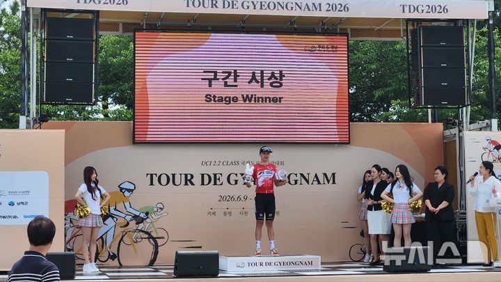 [거제=뉴시스]경남도 주최 '트루 드 경남 2026' 1일차 거제 구간 경기에서 우승을 차지한 일본 팀 우쿄 소속 시모네 라카니 선수가 우승패를 들고 기념촬영하고 있다.(사진=경남도 제공) 2026.06.09. photo@newsis.com